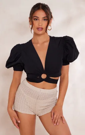 Black poplin crop top with puff sleeves, ring detail, and knotted waist.